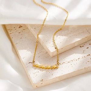 Gold honeycomb smile necklace with diamond-encrusted hexagonal charms on silk and stone