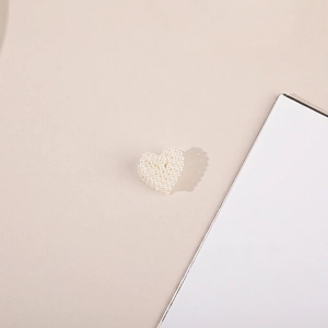Detail shot of heart shaped pearl hair clip with elegant faux pearl embellishments