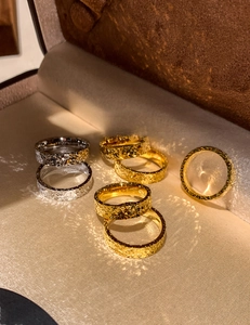 Close-up of 18k gold plated hammered texture rings on beige satin background