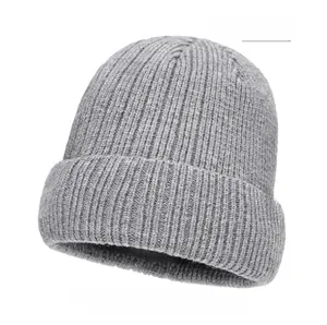 Close-up of light gray ribbed knit beanie with brown leather logo patch detail