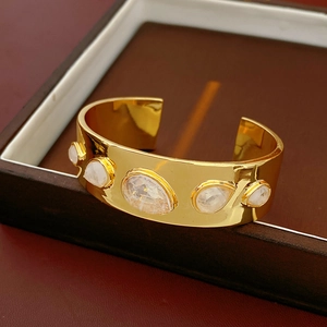 Vue détaillée du bracelet jonc doré orné de cinq pierres blanches incrustées