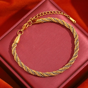Détail d'un bracelet chaîne torsadée bicolore or et argent sur un coffret en velours