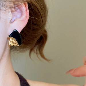 Detail of 18k gold plated geometric resin earring on model with black enamel finish
