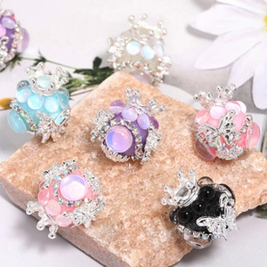 Macro shot of crown and butterfly rhinestone beads for DIY jewelry on a natural stone