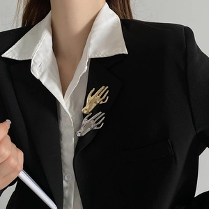 Modern hand-shaped creative brooches in gold and silver finish on black suit jacket