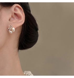 Close-up of elegant gold stud earrings featuring freshwater pearls and cubic zirconia