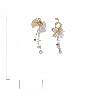 Detail showing asymmetric pearl bow earrings with product dimensions of 12 cm by 5 cm