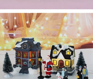Nahaufnahme leuchtendes LED-Weihnachtsdorf mit Weihnachtsmann und Mini-Bäumen
