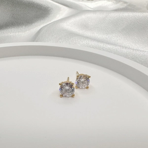Classic round cubic zirconia stud earrings with four-prong gold setting on silk