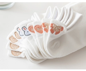Detail of embroidered rabbit and heart patterns on white cotton low-cut ankle socks