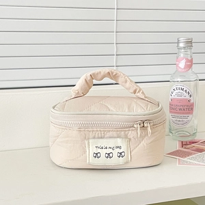 Quilted cream vanity case with top handle and This is my bae bow label design