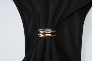 Close-up of golden metal rings detail on a black high-elasticity bodycon dress