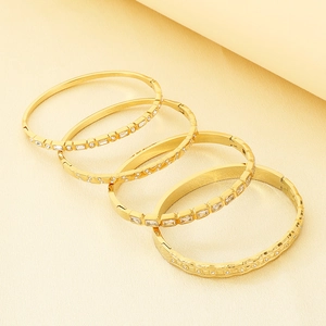 Detailed macro view of four stackable 18K gold plated bangles with CZ stone settings