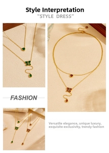 Detail of double-layer gold necklace with green and wine red heart butterfly pendants