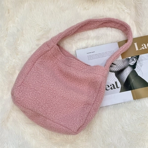 Detailed texture of pink sherpa fleece tote bag on a fluffy white background