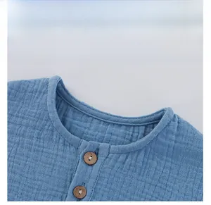 Detail of blue cotton gauze toddler top with waffle texture and wooden buttons