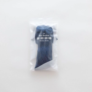 Detail of dark blue knit baby socks with double bow design in clear plastic packaging