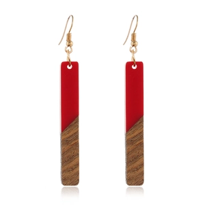 Vue détaillée de boucles d'oreilles rectangulaires en bois et résine rouge avec crochets