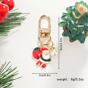 Detail of Santa Claus keychain with red enamel finish and white pearl pendant decor