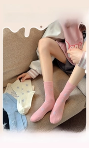 Detail of ribbed knit cotton socks featuring colorful star patterns in various soft shades