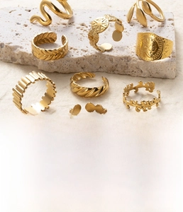 Detail view of gold-plated titanium steel rings featuring vintage snake and coin designs