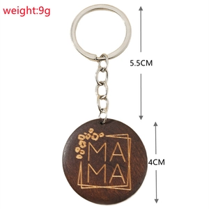 Close-up of wooden MAMA keychain with floral engraving, showing dimensions and 9g weight