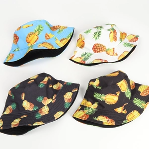 Double-sided sun hat featuring vibrant tropical pineapple prints in blue, white, and black