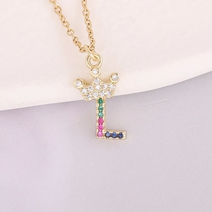 Macro shot of 18K gold letter L pendant with crown and multicolored zircon stones