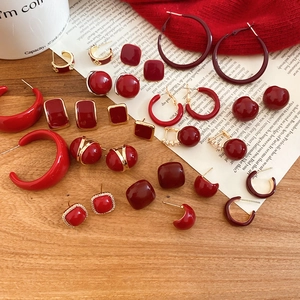 Flat lay of vintage red and gold geometric earring collection on a rustic wooden background
