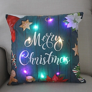 Close-up of LED Christmas pillow with Merry Christmas text and glowing colorful lights