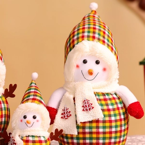 Detail of plush snowman with red green plaid hat and embroidered Christmas tree scarf