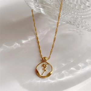 Macro detail of French vintage gold rose necklace pendant with light water ripple reflection