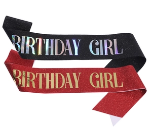 Detail of red and black glitter sashes with golden and silver Birthday Girl lettering