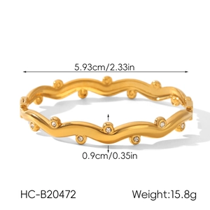 Macro view of wavy gold stainless steel bracelet with zircon inlay and product dimensions