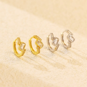 Detail of silver and gold geometric hoop earrings with emerald-cut zirconia stones