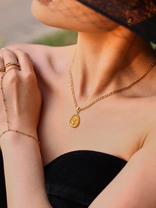 Model wearing a gold-plated sunflower embossed pendant necklace and matching jewelry