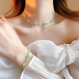 Close-up of pastel floral beaded choker necklace and bracelet set on model