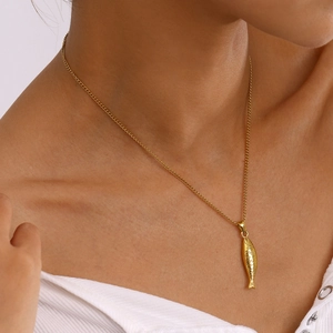 Close-up of a delicate gold fish pendant on a fine stainless steel chain for women