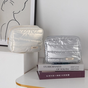 Close-up of quilted metallic makeup bags in pearl white and silver with JIMEIZI logo