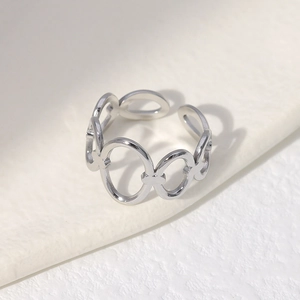Detail of silver adjustable oval ring with polished stainless steel geometric design