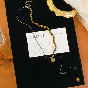 Detail of tiger eye stone pendant necklace with irregular chips and silver chain link