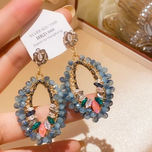 Detail of vintage bow pearl earrings with 925 silver studs and blue beads