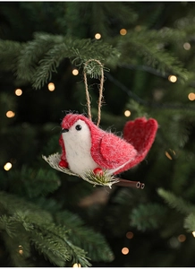 Close-up of red and white felt bird ornament hanging on a Christmas tree branch