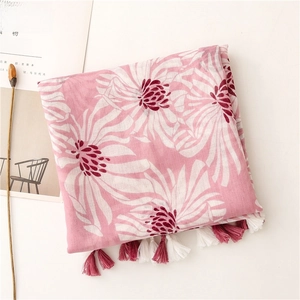 Vue détaillée de l'écharpe rose à imprimé fleuri avec pompons fins et texture douce en coton
