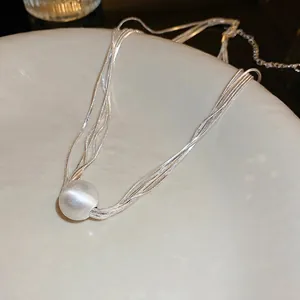Multi-strand silver snake chain necklace featuring a pearly white cat eye bead pendant