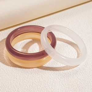 Minimalist geometric resin bangles in purple, amber, and cream white on a clean display