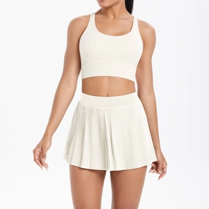 Detail of white two-piece yoga set featuring a pleated tennis skirt and sports bra