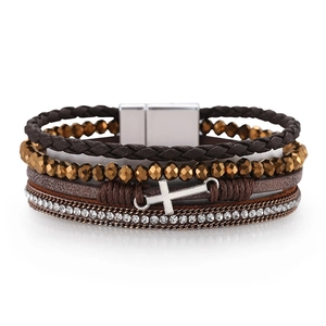 Detail showing multilayer braided leather bracelet with cross charms and magnetic clasp
