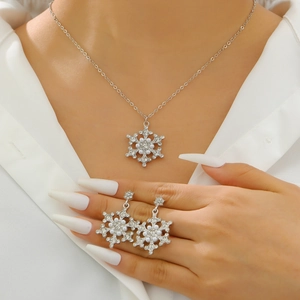 Detail of snowflake pendant necklace and earrings set with crystals and white pearls