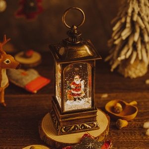 Vintage bronze Christmas lantern with Santa Claus figurine and falling snow scene